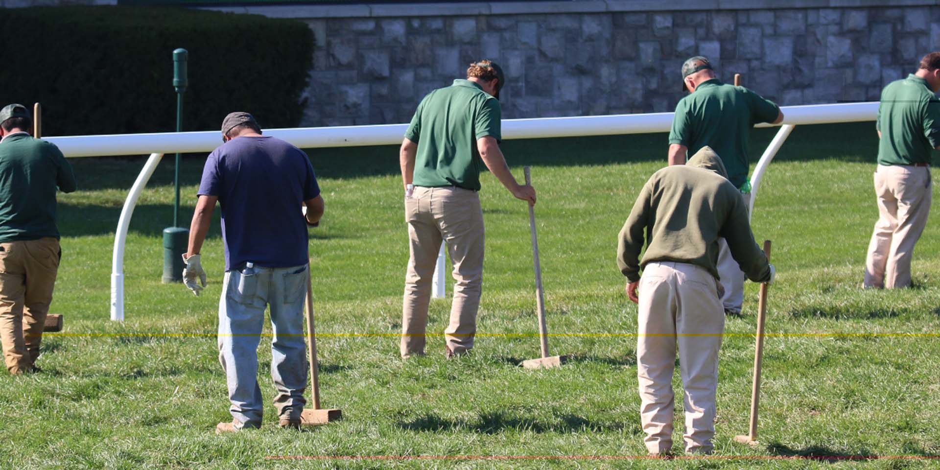 An action shot of Keenhoofbeat team members tamping down turf divots.